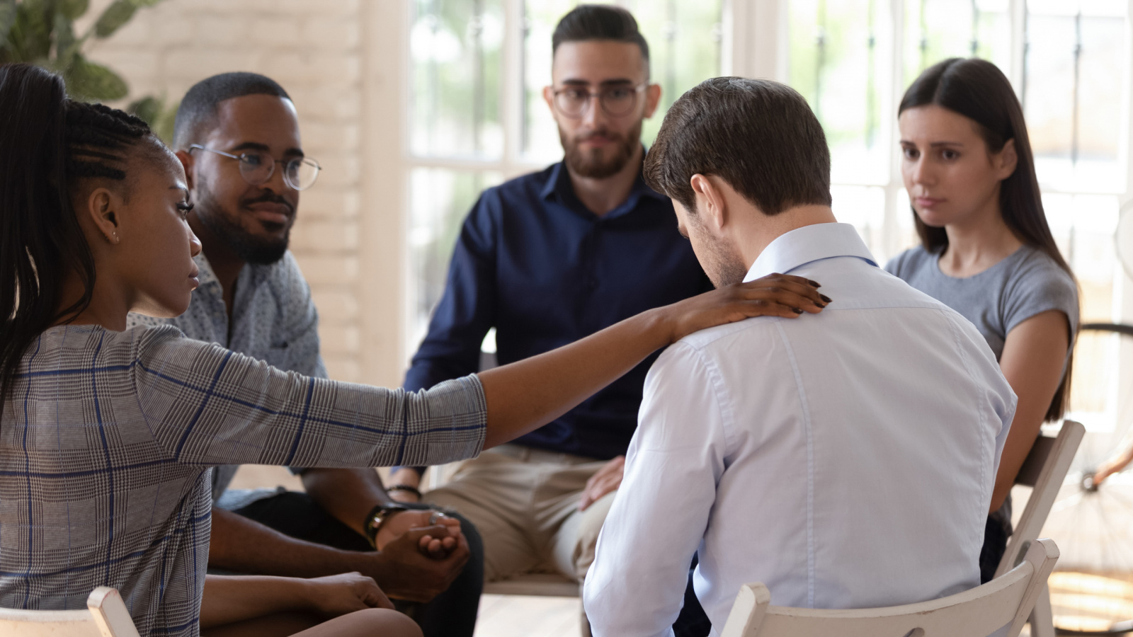 Group counseling session with someone consoling another person